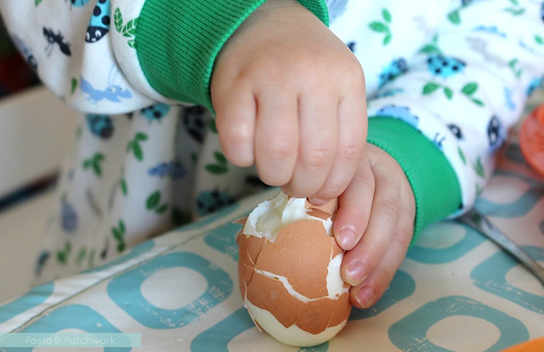 Toddler peeling an egg - close-up